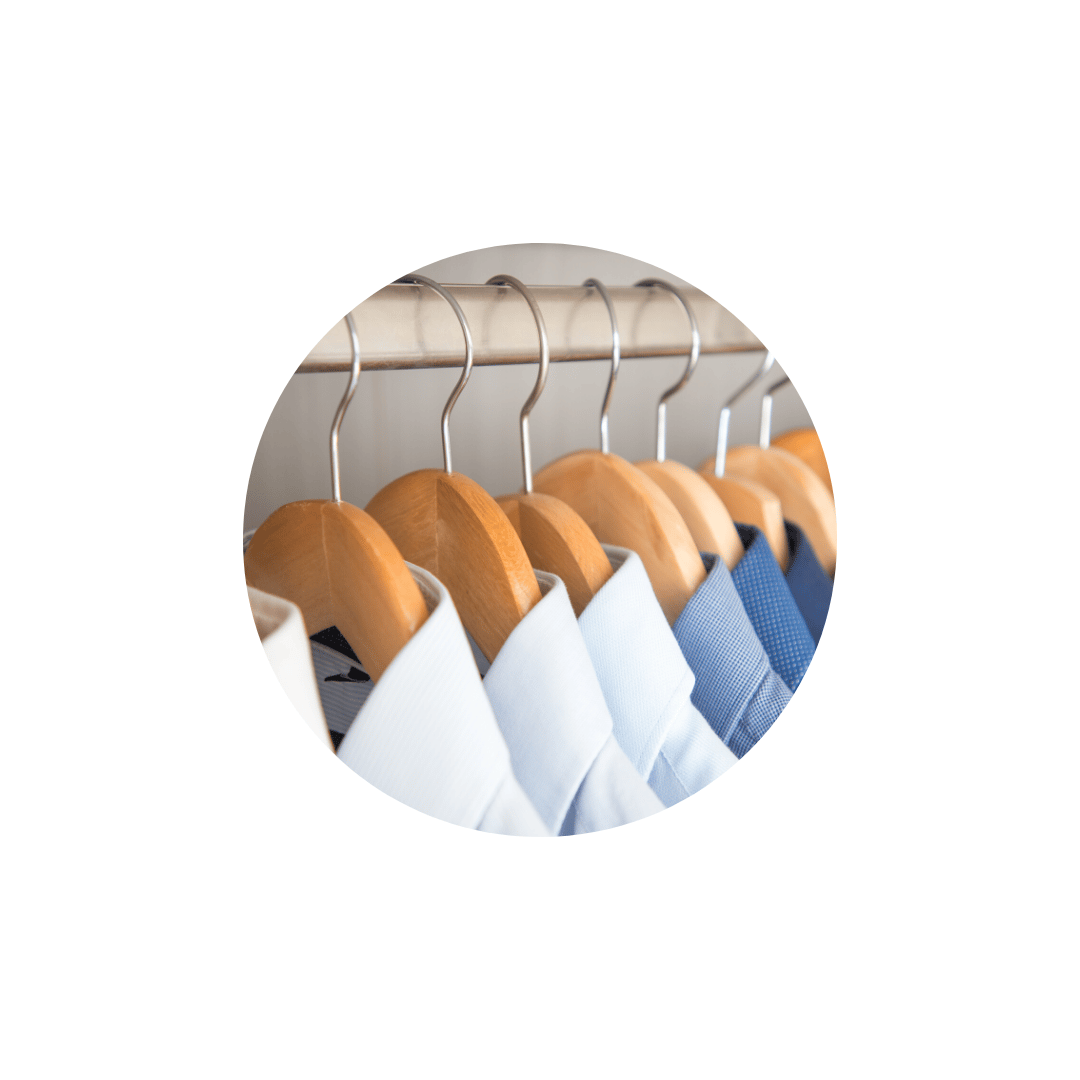 White and blue shirts on wooden hangers with silver hooks
